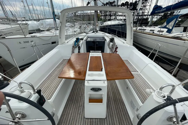 Moonshadow Yacht Photos Pics Cockpit view of 2016 Beneteau Oceanis 38 sailboat with wooden table and dual steering wheels.