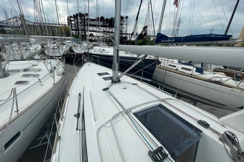 Moonshadow Yacht Photos Pics 2016 Beneteau Oceanis 38 sailboat docked among other yachts in a marina.