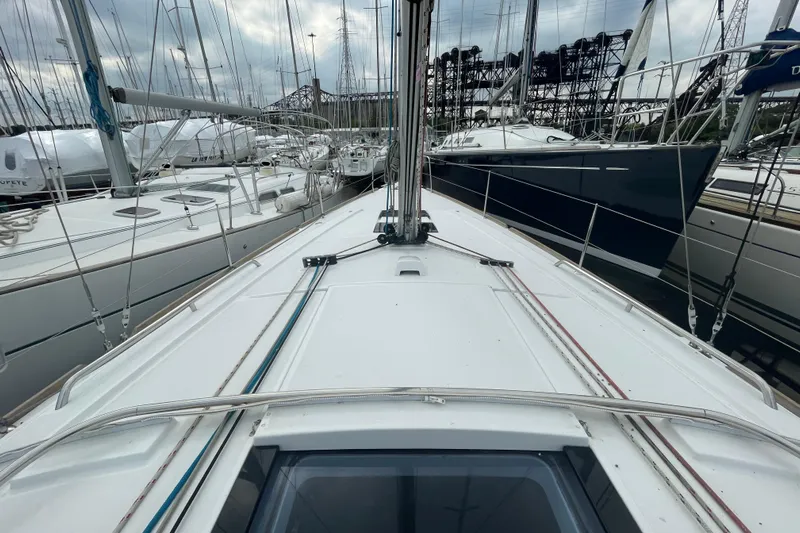 Moonshadow Yacht Photos Pics 2016 Beneteau Oceanis 38 sailboat deck view in marina, surrounded by other yachts.