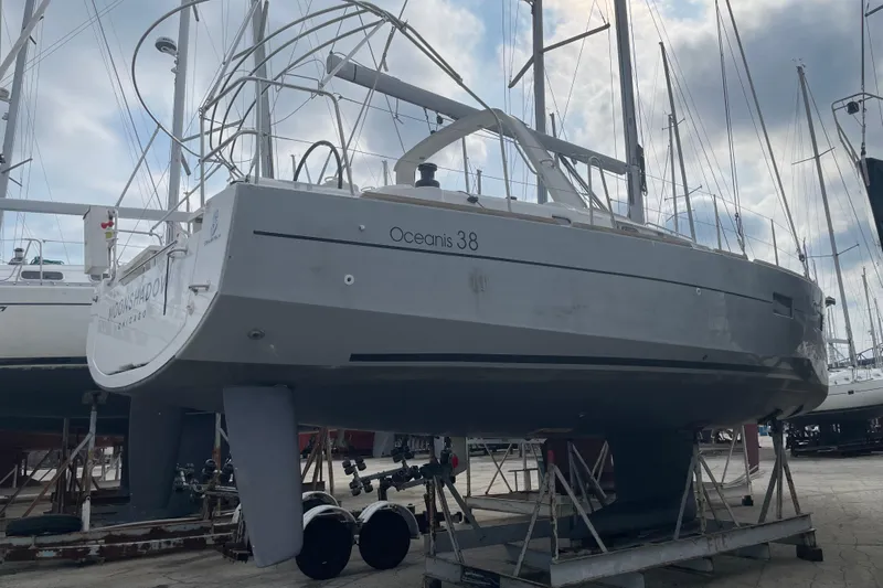 Moonshadow Yacht Photos Pics 2016 Beneteau Oceanis 38 sailboat on dry dock, surrounded by other yachts.