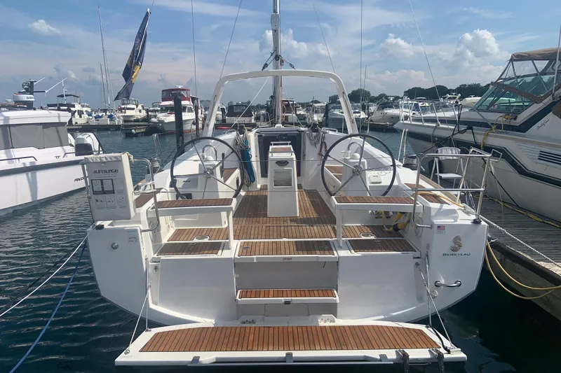 Moonshadow Yacht Photos Pics 2016 Beneteau Oceanis 38 sailboat docked at marina, showcasing spacious deck and dual steering wheels.