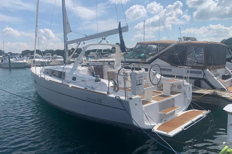 Moonshadow Yacht Photos Pics 2016 Beneteau Oceanis 38 sailboat docked in a sunny marina.