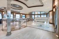 Luxurious yacht interior with elegant decor, featuring a white grand piano and modern design elements.