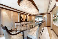 Luxurious yacht dining room with elegant chandelier and glass table, Oceanco Custom 2001 model.