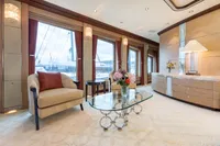 Luxurious yacht interior with elegant furnishings, glass table, and large windows. Oceanco Custom, 2001.