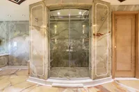 Luxurious marble shower in a 2001 Oceanco Custom yacht bathroom.