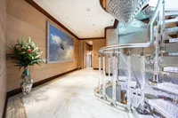 Luxurious yacht interior with spiral staircase, elegant decor, and ocean-themed artwork. Oceanco Custom 2001.