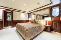 Luxurious yacht bedroom with elegant wood paneling, plush bedding, and ambient lighting, Oceanco Custom 2001.
