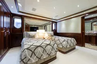 Luxurious yacht bedroom with twin beds, elegant wood paneling, and soft lighting. Oceanco Custom 2001.