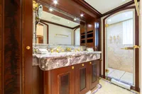 Luxurious yacht bathroom with marble sink, wooden cabinetry, and gold fixtures, Oceanco Custom 2001.