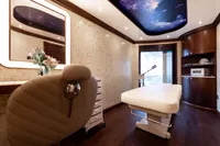 Luxurious spa room on 2001 Oceanco Custom yacht with galaxy ceiling and modern decor.