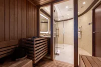 Luxurious yacht sauna interior with wooden panels, glass door, and modern lighting. Oceanco Custom 2001.