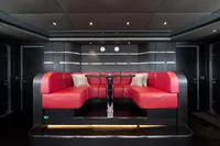 Luxurious yacht interior with red seating, modern design, and ambient lighting, Oceanco Custom 2001.