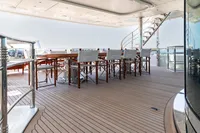 Luxurious yacht deck with dining area, spiral staircase; Oceanco Custom, 2001 model.