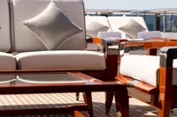 Luxurious deck seating on 2001 Oceanco Custom yacht, featuring elegant wooden furniture.