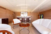 Luxurious yacht interior with bar, modern seating, and elegant wood paneling, Oceanco Custom 2001.