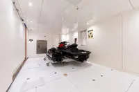 Luxurious yacht garage with jet ski, Oceanco Custom 2001 model, sleek white interior.