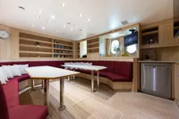 Luxurious yacht interior with red seating, wooden shelves, and modern appliances, Oceanco Custom 2001.