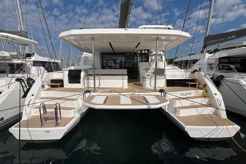 Faste Yacht Photos Pics 2025 Leopard 52 yacht with spacious deck, docked in marina under blue sky.