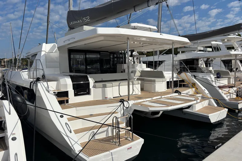 Faste Yacht Photos Pics Modern 2025 Leopard 52 yacht docked, showcasing sleek design and spacious deck.