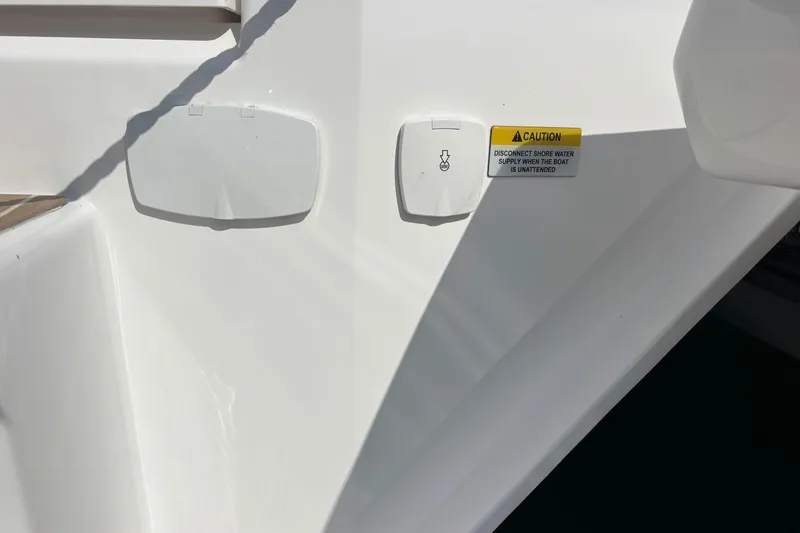 Faste Yacht Photos Pics Close-up of a 2025 Leopard 52 boat's water connection and caution label.