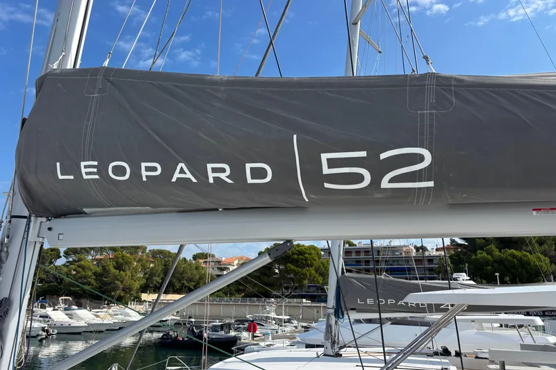 Faste Yacht Photos Pics 2025 Leopard 52 sailboat mast with branding, docked in a marina.
