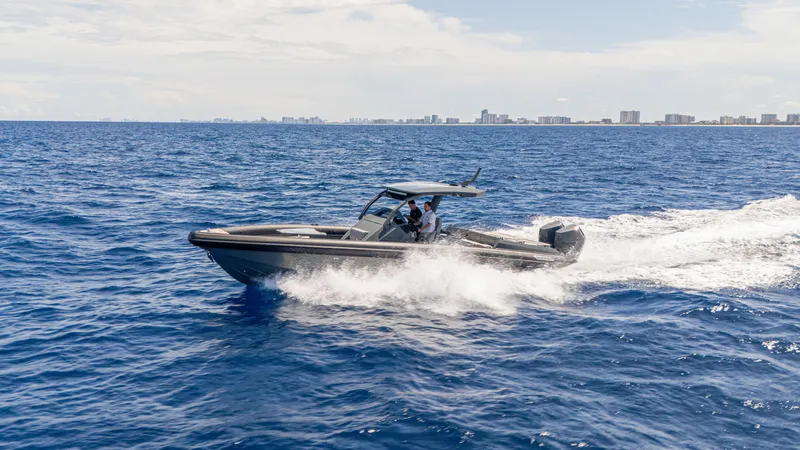 Skipper 38 Twin Mercury 400 Verado - Sunbed Ed. Yacht Photos Pics 2025 Skipper-BSK 38 boat cruising on open sea with city skyline in background.