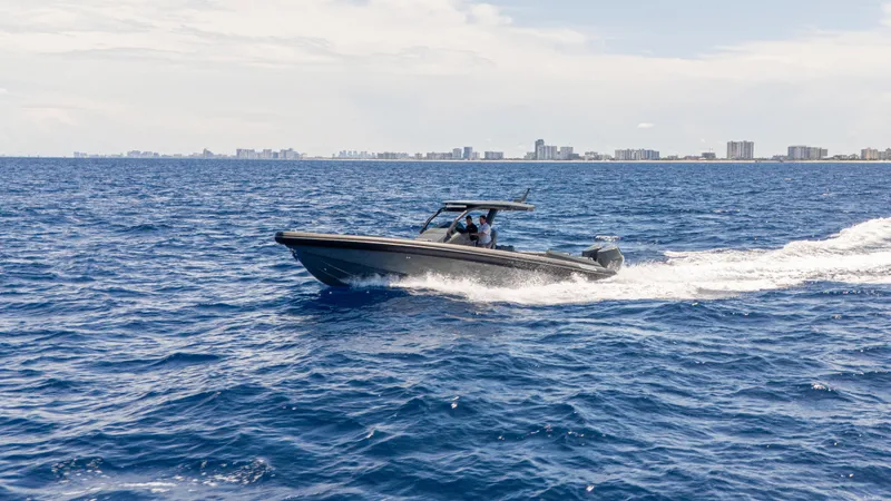 Skipper 38 Twin Mercury 400 Verado - Sunbed Ed. Yacht Photos Pics 2025 Skipper-BSK 38 boat cruising on open ocean with city skyline in background.