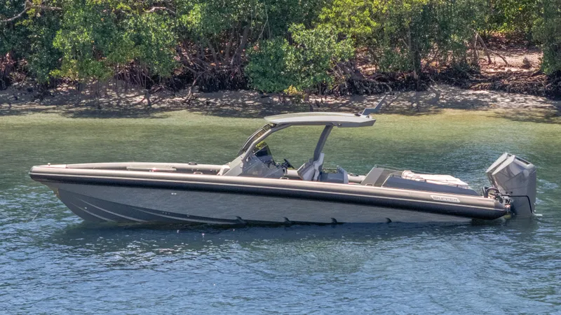 Skipper 38 Twin Mercury 400 Verado - Sunbed Ed. Yacht Photos Pics 2025 Skipper-BSK 38 boat on calm water near lush shoreline.