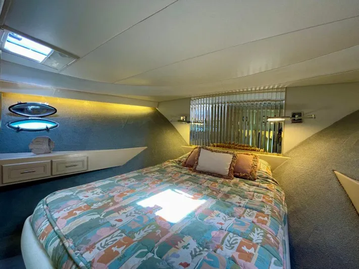  Yacht Photos Pics Cozy bedroom in 1989 Pilothouse West Bay yacht with colorful bedding and modern lighting.