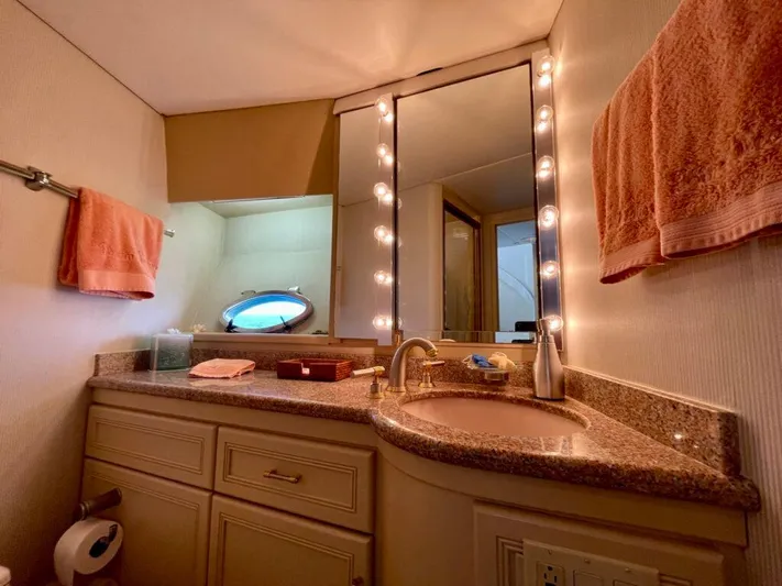 Yacht Photos Pics Luxurious 1989 Pilothouse West Bay bathroom with granite countertop, mirror, and ambient lighting.