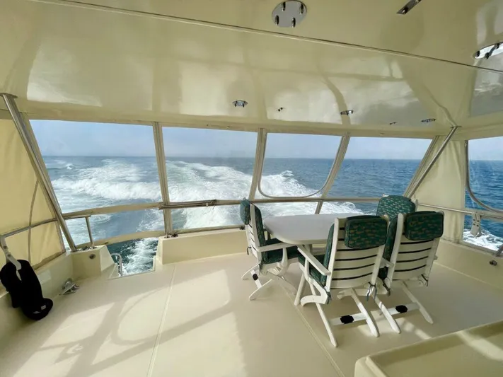  Yacht Photos Pics 1989 Pilothouse West Bay yacht interior with ocean view, featuring a dining table and chairs.