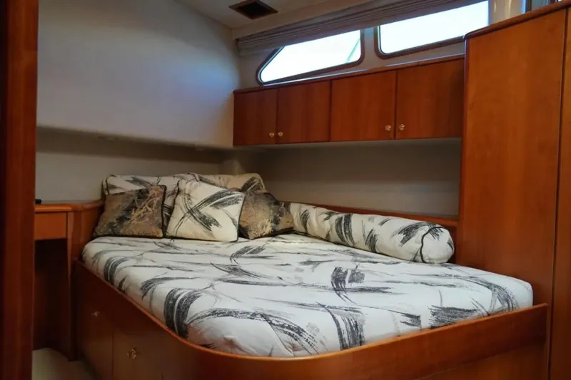 After Midnight Yacht Photos Pics Luxurious cabin interior of 1994 Knight & Carver Lux SF yacht with cozy bed and wooden cabinetry.