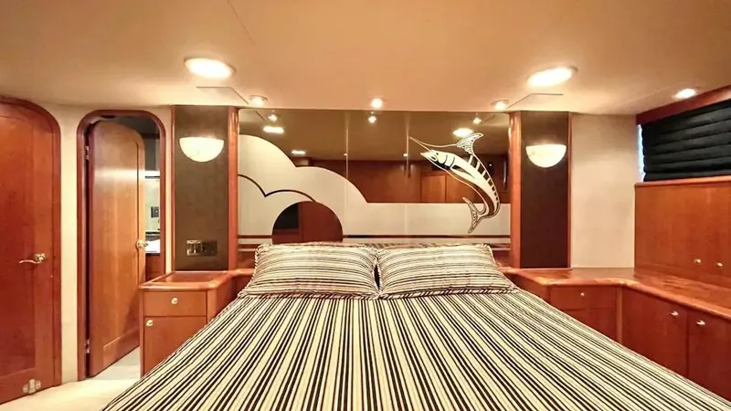 After Midnight Yacht Photos Pics Luxurious yacht bedroom with striped bedding, wood paneling, and marlin artwork, Knight & Carver Lux SF 1994.