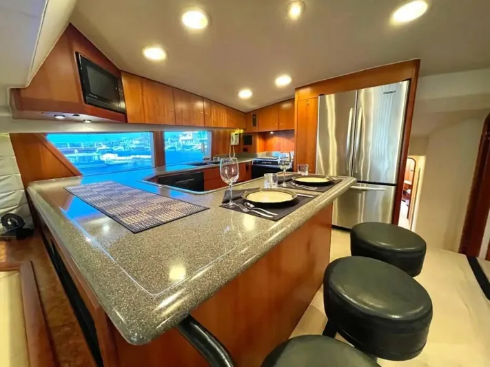 After Midnight Yacht Photos Pics Luxurious yacht kitchen interior with modern appliances, granite countertops, and elegant dining setup. Knight & Carver Lux SF 1994.