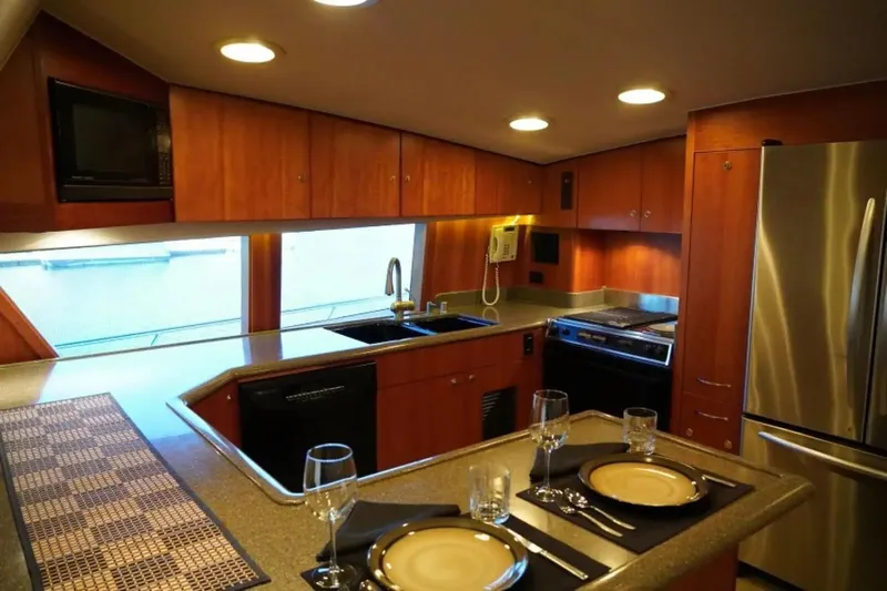 After Midnight Yacht Photos Pics Luxurious yacht kitchen interior with modern appliances, wooden cabinetry, and elegant dining setup, Knight & Carver Lux SF 1994.