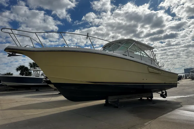 Miss Cissa Yacht Photos Pics 2003 Rampage 38 Express boat on dry dock under cloudy sky.