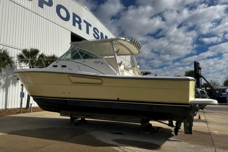 Miss Cissa Yacht Photos Pics 2003 Rampage 38 Express boat on display outside a large building under a cloudy sky.