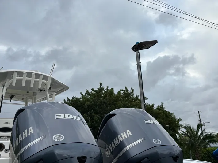  Yacht Photos Pics 2021 Cobia 301 Center Console with twin Yamaha 300 engines under cloudy sky.