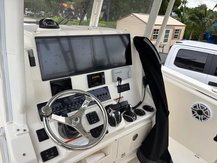  Yacht Photos Pics 2021 Cobia 301 Center Console boat dashboard with steering wheel and electronic displays.