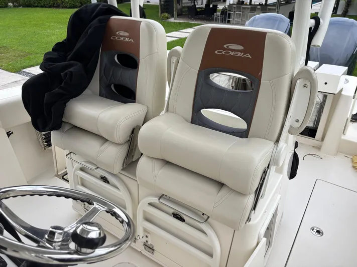  Yacht Photos Pics 2021 Cobia 301 Center Console boat seats with steering wheel, featuring luxurious design.