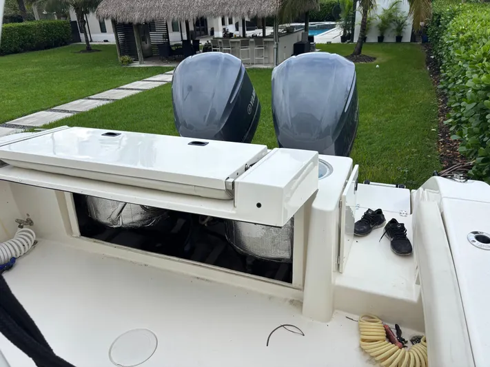  Yacht Photos Pics 2021 Cobia 301 Center Console boat with dual engines, parked in a lush backyard.