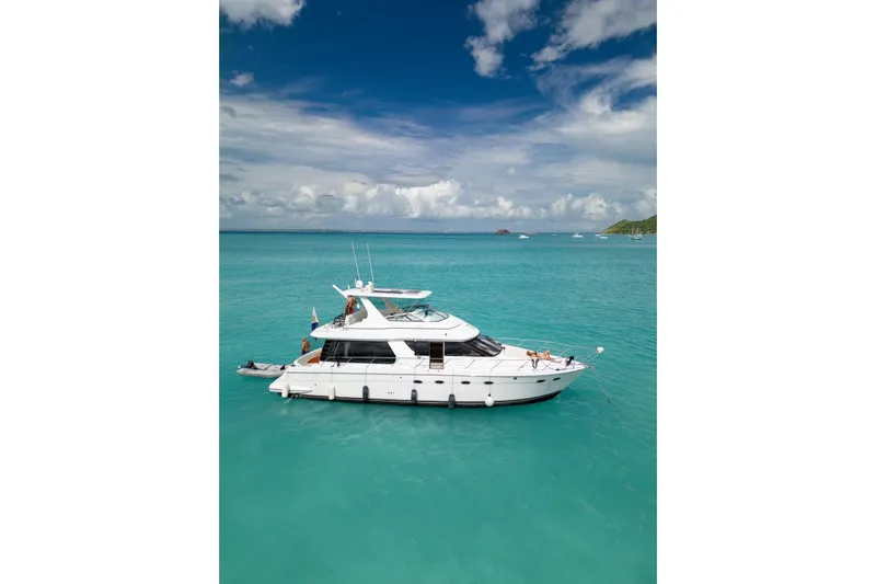  Yacht Photos Pics 2000 Carver 530 Voyager Pilothouse yacht on turquoise water under a partly cloudy sky.