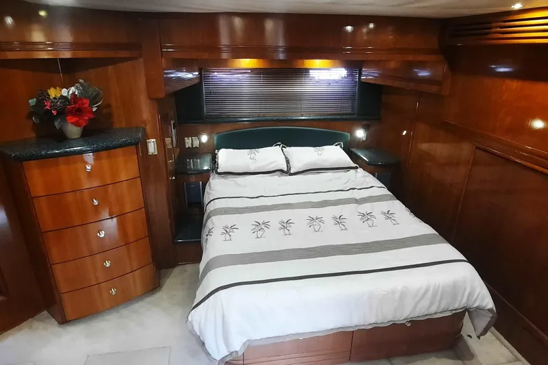  Yacht Photos Pics Luxurious bedroom interior of 2000 Carver 530 Voyager Pilothouse yacht with wood paneling.