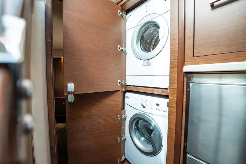 No Shoes Yacht Photos Pics Laundry area with stacked washer and dryer in 2013 Sea Ray 580 Sundancer yacht.