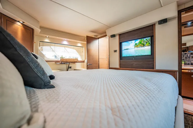 No Shoes Yacht Photos Pics Luxurious bedroom interior of 2013 Sea Ray 580 Sundancer yacht with TV and window view.