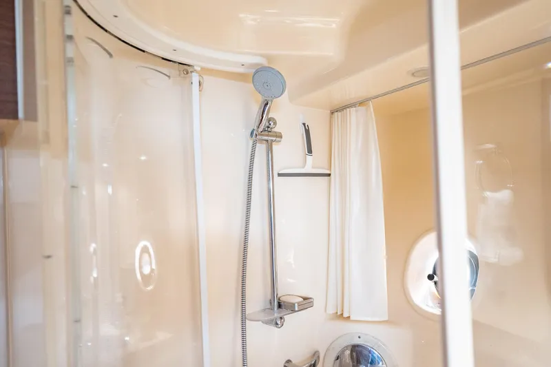 No Shoes Yacht Photos Pics Shower area in 2013 Sea Ray 580 Sundancer yacht, featuring modern fixtures and porthole window.