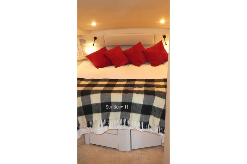  Yacht Photos Pics Cozy bedroom in 1994 Bayliner 4388 Motor Yacht with red pillows and plaid blanket.