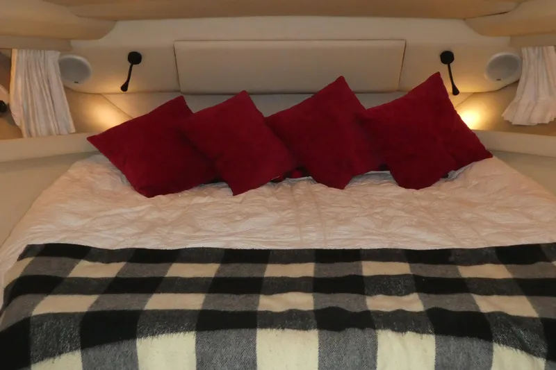  Yacht Photos Pics Cozy bedroom in 1994 Bayliner 4388 Motor Yacht with red pillows and plaid blanket.