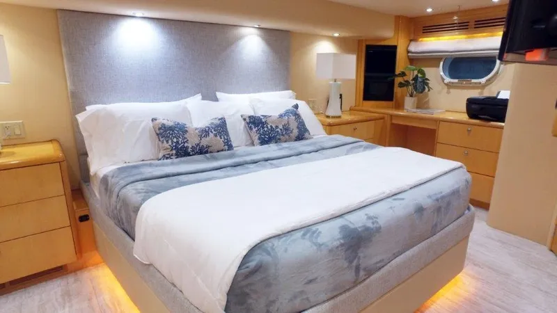 Jolley Roger Yacht Photos Pics Luxurious bedroom interior of 2006 Hatteras Enclosed Bridge yacht with elegant bedding and ambient lighting.